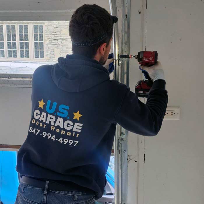 Our US Garage Door Repair technician using a battery-powered screwdriver to finish installing a track on a brand new garage door in Lake Zurich, IL