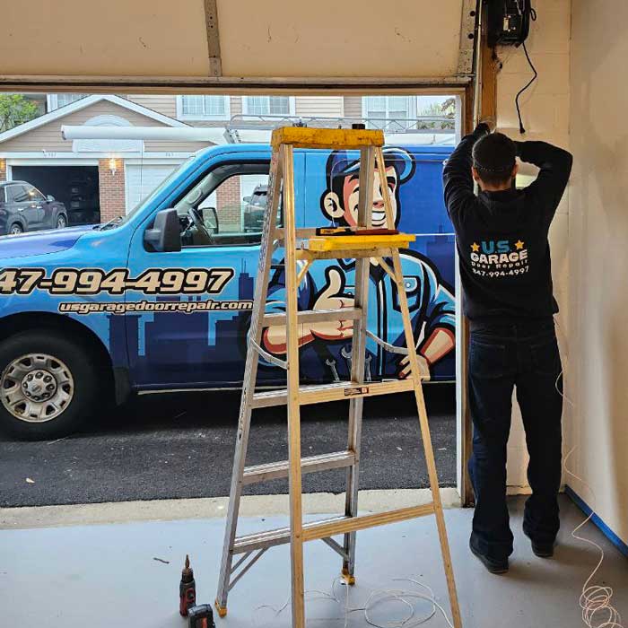 Our US Garage Door Repair technician fixing garage door in North Barrington, IL and our work truck is in the background